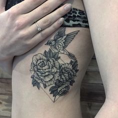 a close up of a person's stomach with flowers on it and a bird