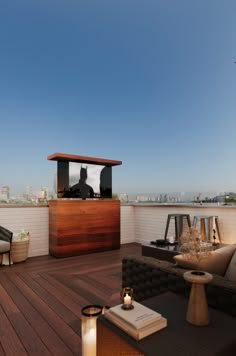 an outdoor bar on the roof of a building with wooden floors and furniture around it