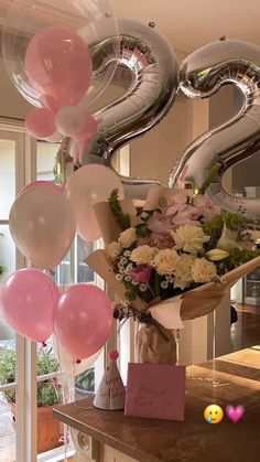 a bouquet of flowers and balloons are on the counter