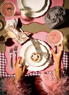 a woman is sitting at a table with plates and utensils on her hands