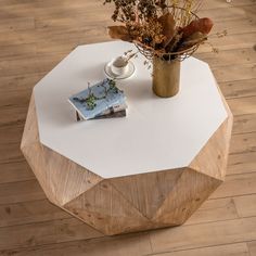 a coffee table with a magazine on it and flowers in a vase next to it