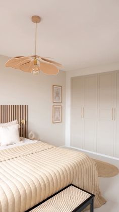 a bedroom with a bed, dressers and a ceiling fan in the middle of it