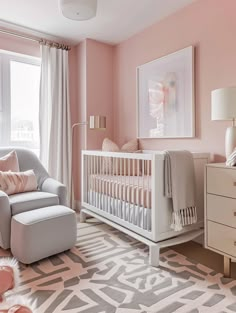 a baby's room with pink walls and white furniture