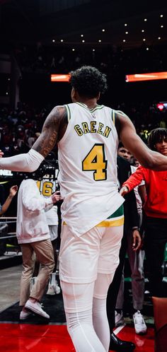 a basketball player walking on the court with his foot in the air and people watching