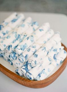 folded blue and white cloths in a wooden bowl