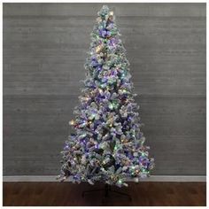 a white christmas tree with multicolored lights on it's top and bottom