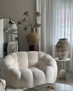 a living room filled with white furniture and vases on top of each other's sides