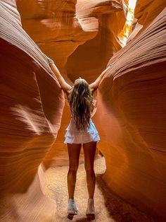 a woman standing in the middle of a canyon