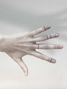 a person's hand with rings on it is reaching out to the sky in front of a white background