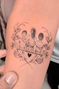 a woman's arm with a tattoo on it that has three people sitting in a heart