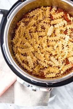 an overhead view of pasta in the instant pot with sauce and parmesan cheese