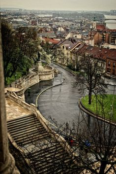 an aerial view of a river running through a city with stairs leading up to it