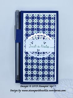 a note book with a pen next to it on top of a doily paper