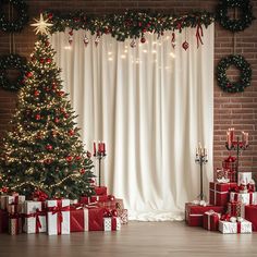 a christmas tree and presents in front of a brick wall with lights on the windows