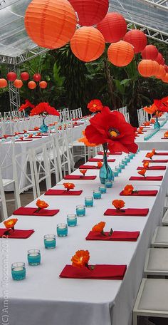 a long table is set up with red and blue place settings for an outdoor event