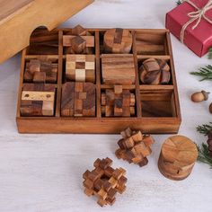 a wooden box filled with pieces of wood next to pine cones and other christmas decorations