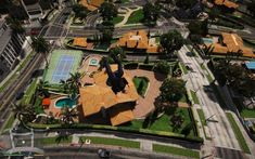 an aerial view of a tennis court and surrounding buildings in a city with palm trees