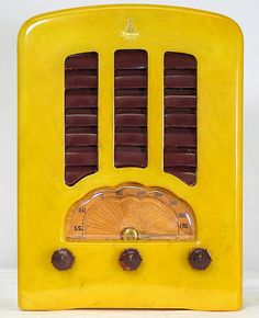 an old yellow radio sitting on top of a table