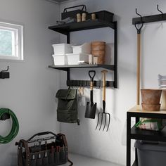 a kitchen with pots, pans and utensils hanging on the wall next to a window