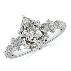 a diamond engagement ring with three stones on the band and an oval shaped center stone