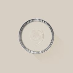 a white paint can with a long shadow on the wall in front of it's lid