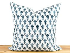 a blue and white pillow sitting on top of a wooden table