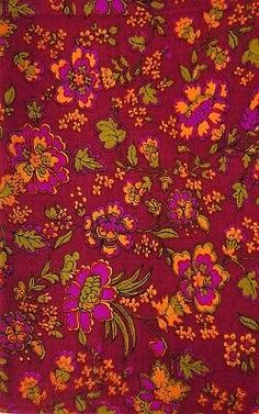 a red and orange flowered cloth with green leaves on it's edges,