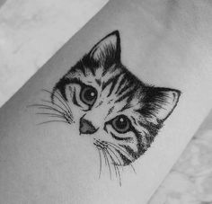 a black and white photo of a cat's face on the ankle tattoo design