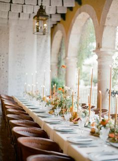 a long table is set with candles and flowers for an elegant dinner party or reception