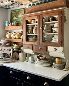 an old china cabinet with dishes on it