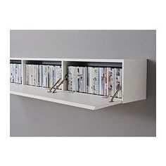 a white shelf with several dvd's on it and two metal hooks in the middle