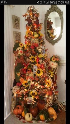 a decorated christmas tree with pumpkins and gourds on it in a living room