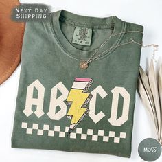 Gear up for the school year with the ABCD Teacher Shirt, crafted from premium Comfort Colors material. Whether you're a Kindergarten or Elementary School teacher, this Back To School Shirt brings both comfort and a fun, educational vibe to your wardrobe. It's also a great Gift for Teachers who love making learning fun. ABOUT US: ✔ Looking for soft, personalized T-shirts that showcase your unique style? Our custom tees are designed for comfort and self-expression! ✔ We are a small, family-owned shop focused on creating high-quality, one-of-a-kind T-shirts and sweatshirts. Each piece is custom-made in our workshop with care and precision.  ✔ Whether it's choosing your favorite color or adding a custom design, we've got everything you need to create the perfect shirt for you. Got any question Elementary School Shirt Designs, School Shirt Designs, Kindergarten Teacher Shirts, Teaching Shirts, Elementary School Teacher, Kindergarten Teacher, Great Teacher Gifts, Create Shirts, Gift For Teacher