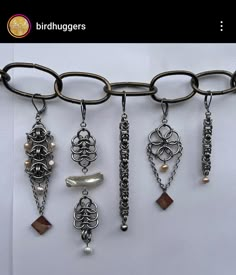 a bunch of necklaces hanging from a metal hook on a white background with the words birdhaggers above them