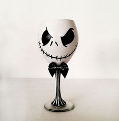 a wine glass that has been painted to look like jack skellingy