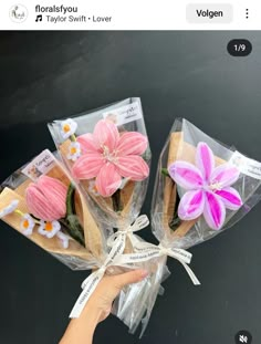 someone is holding up some fake flowers in their hand and it looks like they are made out of cookies