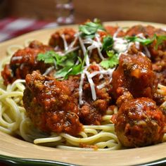 spaghetti and meatballs on a plate with parmesan cheese