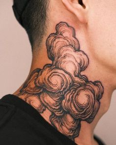 a man with a neck tattoo that has flowers on the back of his head and clouds in the background