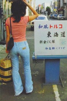 a woman is standing in front of a sign