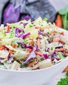 a white bowl filled with coleslaw and carrots on top of a table