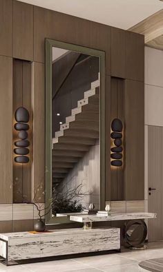 a large mirror sitting on top of a wooden table next to a stair case in a living room