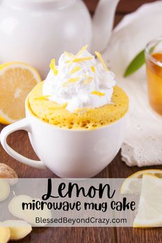 lemon microwave mug cake with whipped cream on top and sliced lemons in the background