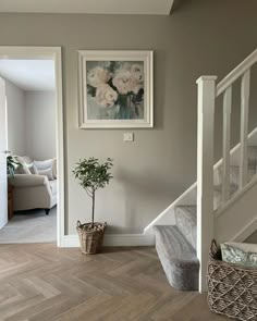 a living room with stairs and pictures on the wall