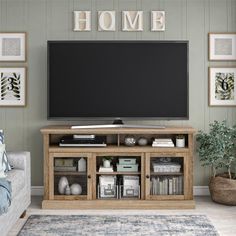 a flat screen tv sitting on top of a wooden entertainment center