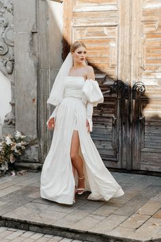 a woman in a white wedding dress standing on steps