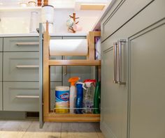 an open cabinet in a kitchen filled with cleaning products