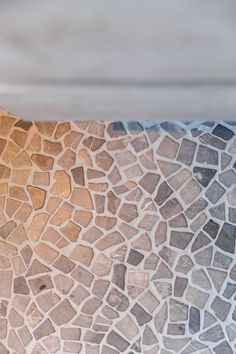 a close up view of a wall made out of small rocks and stones, with the light shining on it