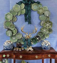 a wooden table topped with plates and vases next to a deer's head