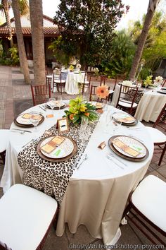 the table is set with plates and place settings for guests to sit down at it