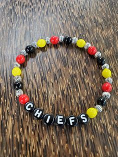 Kansas City Chiefs beaded bracelet made with red, yellow, and black glass and pewter beads. We can also personalize it with any names. Kc Chiefs Beaded Bracelet, Personalized Red Name Bracelet With Round Beads, Red Beaded Name Bracelet With Round Beads, Red Beaded Name Bracelet, Personalized Yellow Beaded Bracelets, Personalized Yellow Beaded Bracelets With Round Beads, Customizable Black Beaded Bracelets, Kansas City Chiefs Craft, Chiefs Crafts